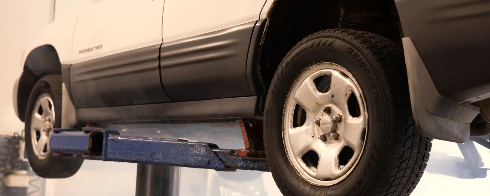 A car raised on a service lift in a repair shop